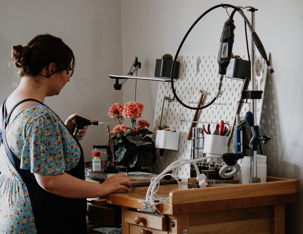 Sophie Butler creating jewellery at the bench in her home. 